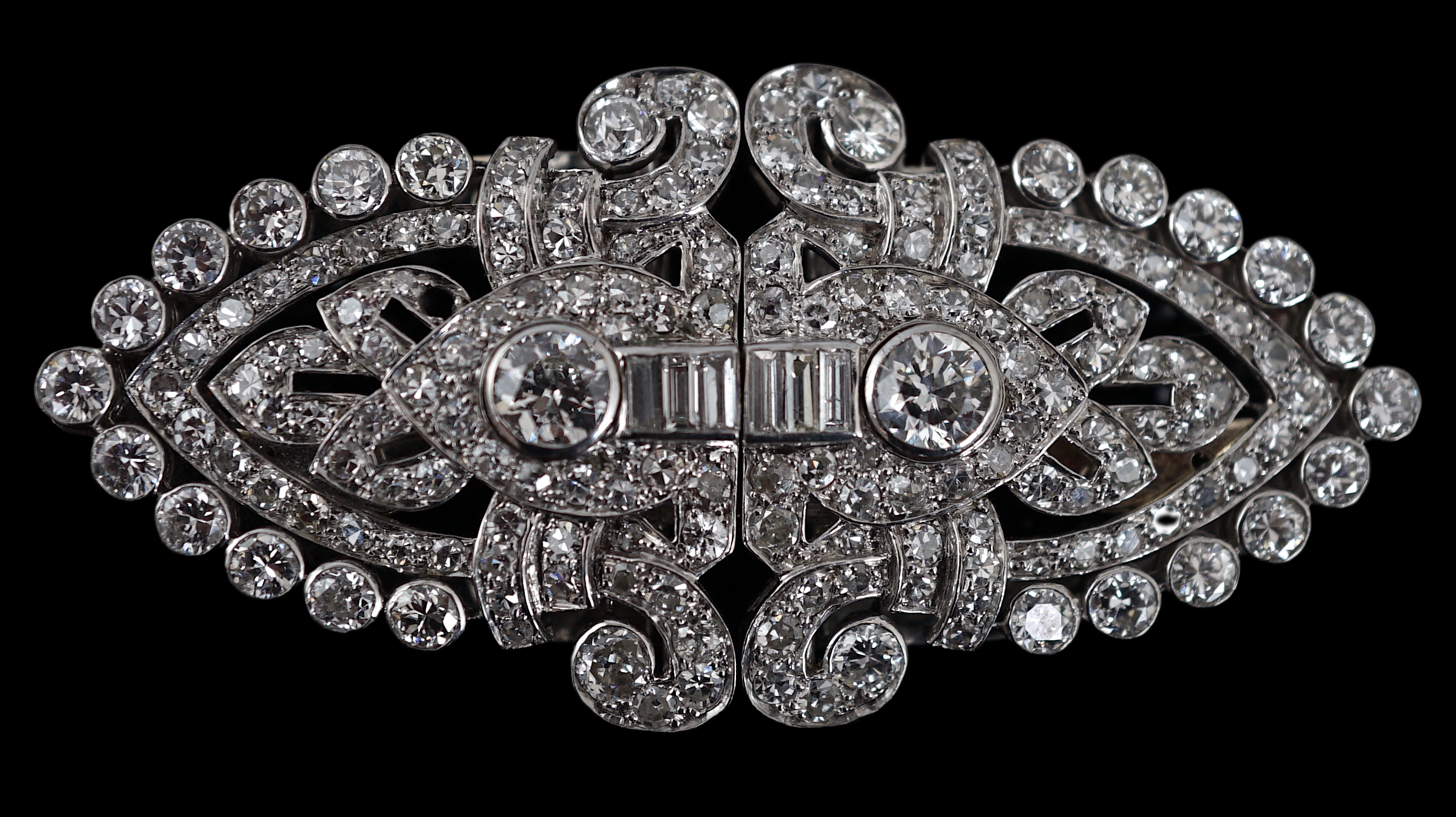 An Art Deco white gold, round and baguette cut diamond set double clip brooch